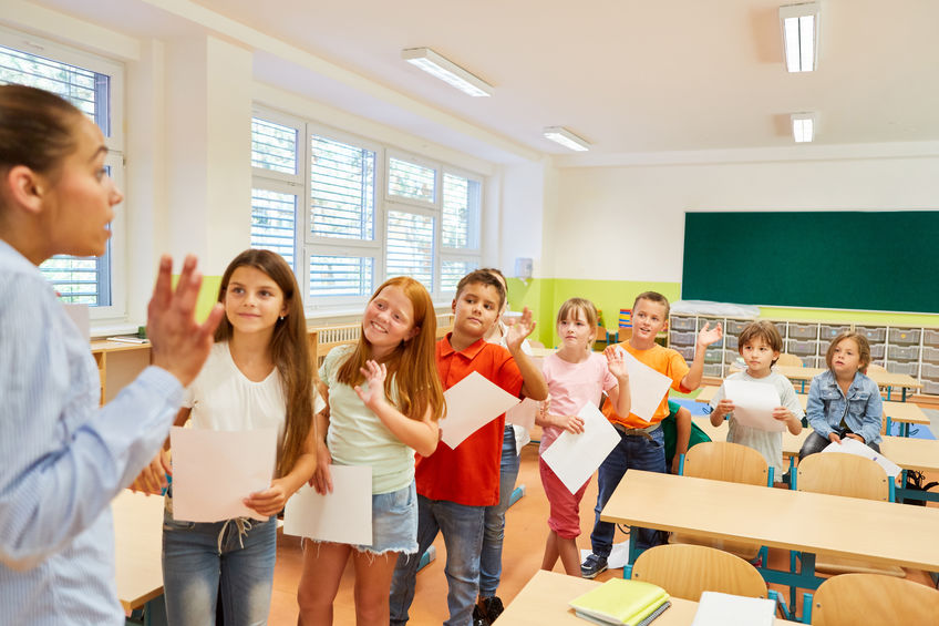 Elementary school children waving at teacher