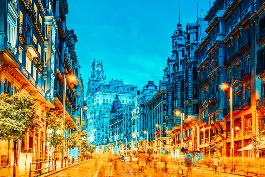 Gran Via Street in Madrid, after sunset, traffic lights on Gran Via, main shopping and financial street in Madrid at night.