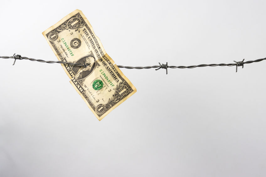 One dollar bill hanging on barbed wire with white background and copy space