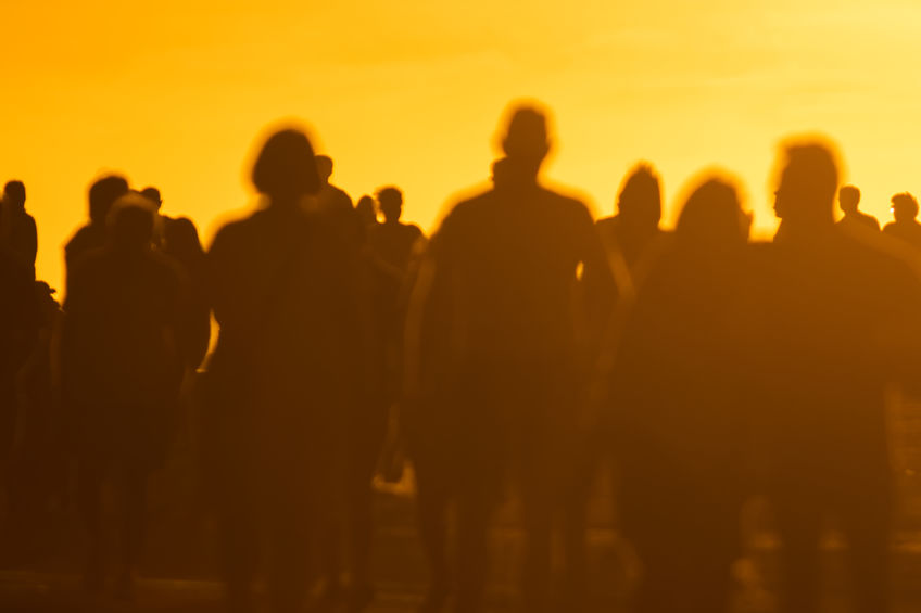 Silhouettes of young people walking at sunset