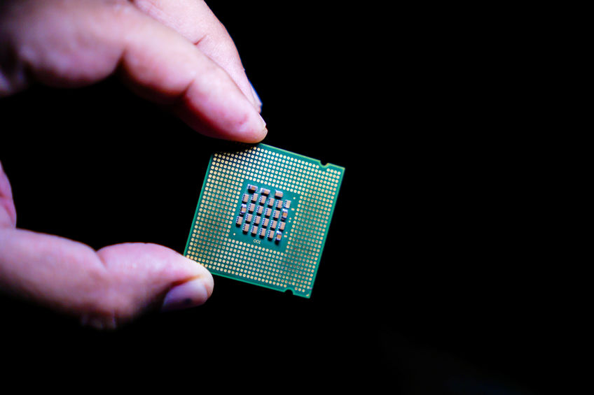 Computer CPUs in the hands of men on a black background.