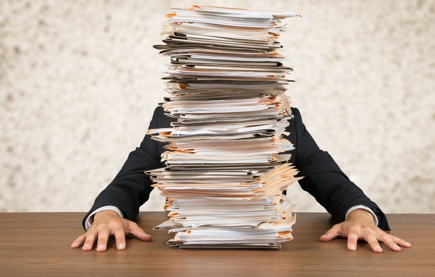 Young businessman with stack of papers