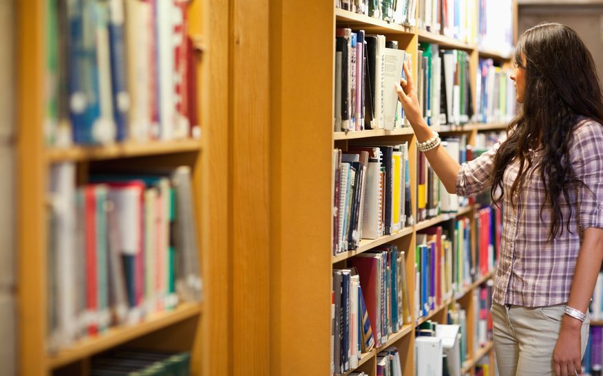 11184727 young woman choosing a book in a library