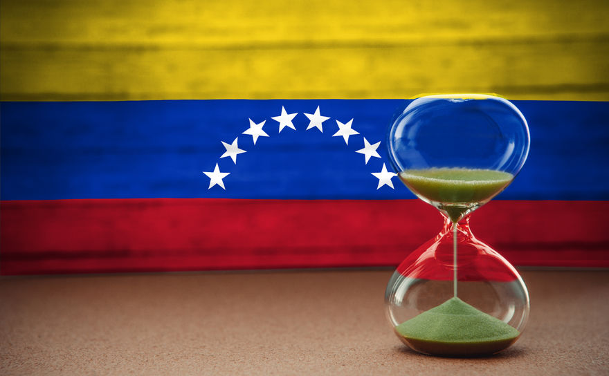 Hourglass on the background of the Venezuela flag, the concept of time and countries, space for text