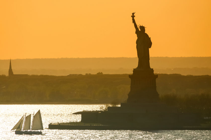 Boat sailing next to Statue of Liberty