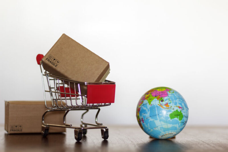 Shopping Trolley with carton and earth globe. Worldwide shopping and delivery business concept